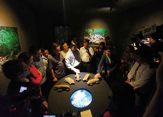 Du khách tham quan Nhà triển lãm âm thanh và trải nghiệm nghệ thuật tương tác chạm tay vào đá tạo âm thanh